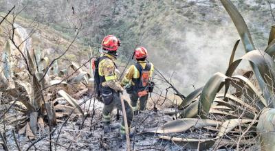 Dos bomberos en un incendio forestal en Quito, el 1 de septiembre de 2023.