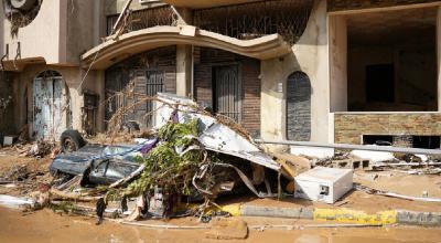 Daños causados por las inundaciones en vehículos y edificios en una calle de Derna, ciudad al este de Libia.