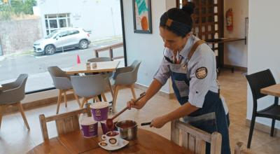 Una trabajadora de la cafetería Caffé & Nata, en el centro norte de Quito, sirve colada morada en una taza. Foto del 14 de septiembre de 2023. 