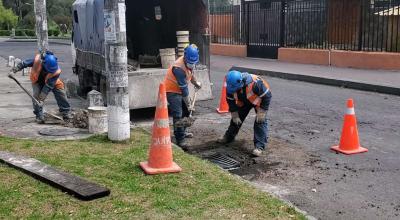 Personal de la Epmaps reemplaza la rejilla de una alcantarilla en Quito, en 2023. 