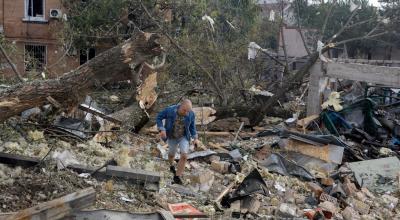 Un residente de Kiev (Ucrania) camina por los escombros causados por un misil de Rusia.