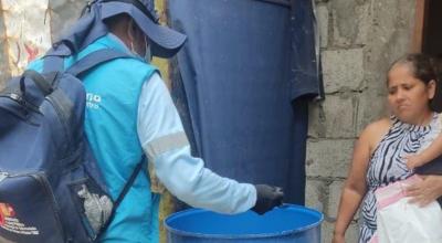 Personal del MSP limpia el tanque donde una mujer almacena agua en Puerto Hondo, para eliminar criaderos de mosquitos, transmisores del dengue, el 6 de octubre de 2023. 