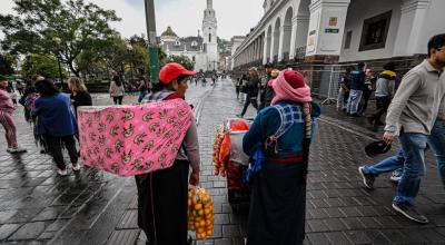 Dos mujeres indígenas venden frutas en el centro de Quito, el 15 de agosto de 2023. 
