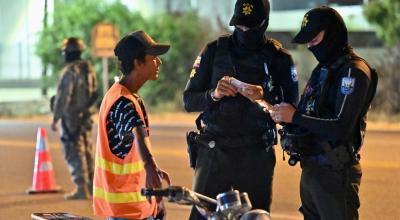 Dos policías verifican los documentos a un hombre a bordo de una moto, en Durán, cantón de Guayas, azotado por la violencia criminal, el 8 de octubre de 2023. 