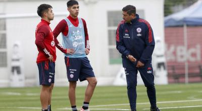 Nicolás Córdova conversa con dos futbolistas en un entrenamiento, en Santiago, el 17 de noviembre de 2023.