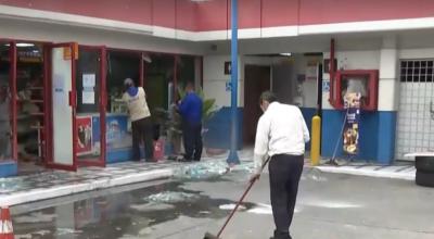 Un trabajador de la gasolinera limpia los restos de los vidrios, tras el robo de un cajero automático, Guayaquil, el 29 de noviembre de 2023.