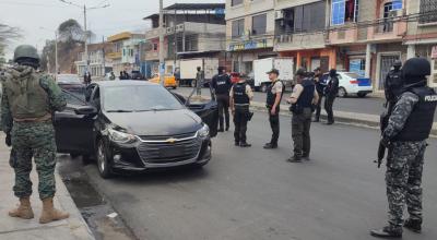Varios policías de unidades especiales junto a militares durante la requisa a un auto en Durán, Guayas, el 6 de diciembre de 2023.