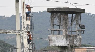 Imagen referencial de dos reos subiendo a un poste en la Penitenciaría del Litoral, durante un motín carcelario, en agosto de 2023.