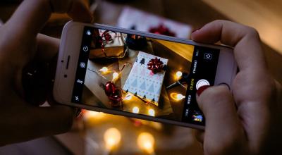 Imagen referencial de una persona tomando una fotografía a un regalo en Navidad.