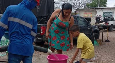 Una familia recibe agua de un tanquero en Guayaquil.