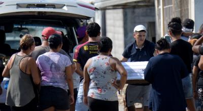 Un hombre carga el ataúd de uno de los cuatro niños asesinados, tras una nueva masacre en el Guasmo Sur, al sur de Guayaquil.