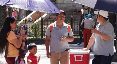 Personas utilizan sombrillas para protegerse del calor en el centro de Cuenca el 26 de enero de 2024.