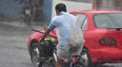 Imagen referencial de un ciclista protegiéndose de la lluvia con un plástico.  En cinco provincias de la Costa se prevén lluvias de nivel alto y muy alto.