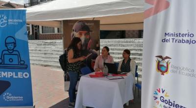 Una joven realiza consultas a funcionarios del Ministerio de Trabajo, que participan en una feria de artesanos, en Loja, en marzo de 2023. 