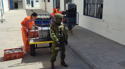 Bajo custodia militar, los presos movilizan la comida que se repartirá en los pabellones del CRS Cotopaxi.