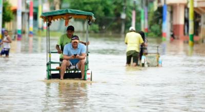 Un ciudadano en un sector inundado en Chone, tras las fuertes lluvias del 21 de febrero de 2024.
