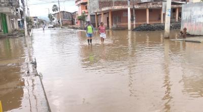 Habitantes del cantón Chone, en Manabí, caminan por las calles inundadas el 23 de febrero de 2024. 