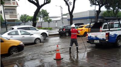 Personal de Interagua desfogando el agua en una avenida del norte de Guayaquil, el 1 de marzo de 2024.