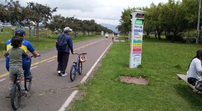 Ciudadanos miran un solmáforo en el parque Bicentenario de Quito en marzo 2024.