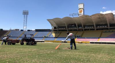 Dos personas trabajan en el césped del estadio Olímpico Atahualpa, uno de los que puede ser considerado para que se juegue la Copa América 2028. 