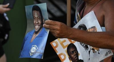 Un vendedor muestra carteles de la leyenda del fútbol brasileño Pelé afuera del estadio Urbano Caldeira, donde se llevó a cabo un velorio en su honor, el 2 de enero de 2023.