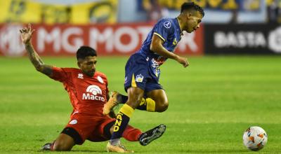 Maikel Reyes AlcÍvar (d) de Delfín disputa el balón con Ariel GarcÍa de Belgrano este 11 de abril de 2024, en un partido de la fase de grupos de la Copa Sudamericana.