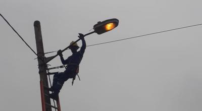 Imagen referencial de un trabajador de CNEL EP arreglando una luminaria de alumbrado público en Guayas. 