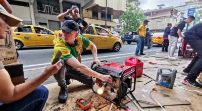 Un dependiente prende y prueba un generador eléctrico portátil en las calles Rumichaca y Aguirre, en el centro de Guayaquil, mientras le explica el funcionamiento a una compradora.