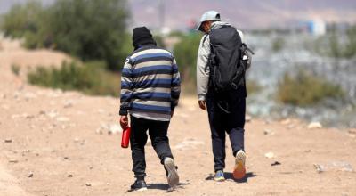 Los migrantes ecuatorianos Luis Hernández Saldaña (40) y Javier Villareal (45) caminan por las orillas del Río Bravo en busca de una brecha para cruzar a Estados Unidos desde Ciudad Juárez, en México.