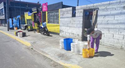 Habitantes del barrio Pilsulí Alto, en el norte de Quito, colocan baldes frente a sus viviendas, el 24 de abril de 2024.
