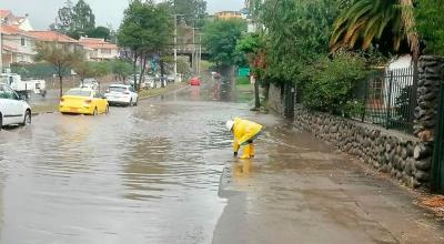 Funcionario de Etapa, en Cuenca, trabaja en una calle inundada, este 24 de abril de 2024.