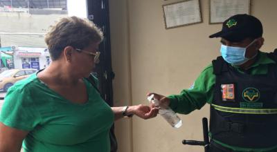 Un guardia de seguridad entrega gel antibacterial a cada paciente que ingresa al centro de salud primario en Guayaquil. 