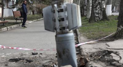 Un hombre pasa junto a una sección de cola sin explotar de un cohete de 300 mm que parece contener bombas de racimo lanzadas desde un lanzacohetes múltiple BM-30 Smerch incrustado en el suelo después de un bombardeo en Lysychansk, región de Lugansk, el 11 de abril de 2022.