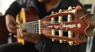Hugo Chiliquinga, tercera generación de una familia de lutieres dedicada al arte de fabricar cordófonos, toca una guitarra, uno de los principales instrumentos en el pasillo ecuatoriano.