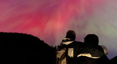 Una pareja observa una aurora boreal, el 11 de mayo de 2024 en Manning Park, Columbia Británica, Canadá.