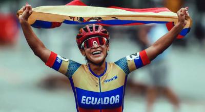 La patinadora, Gaby Vargas, tras lograr un triunfo en patinaje, celebra con la bandera de Ecuador.
