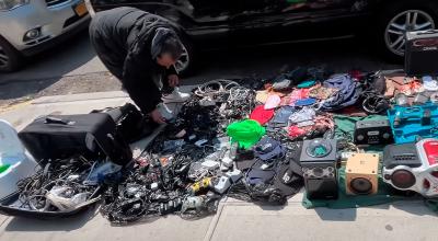 Migrante vende productos usados en una calle de Nueva York.