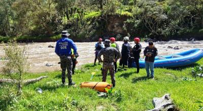 Policías y bomberos en el río Paute, en donde localizaron un cuerpo sin vida el 23 de mayo de 2024.