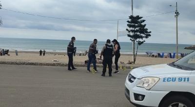 Miembros de la Policía Nacional realizan el levantamiento de un cadáver, en la playa de Jaramijó.