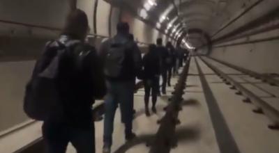 Pasajeros caminan entre los rieles del Metro de Quito, durante el apagón nacional, el 19 de junio de 2024.