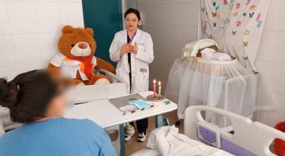 Profesional de la salud acompaña a una madre en el Hospital Vicente Corral Moscoso de Cuenca.