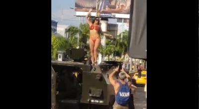 Una mujer en bikini baila sobre una tanqueta militar en Manta en julio 2024.