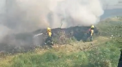 Bomberos controlan un incendio forestal sobre hierba seca en el sector de El Recreo, en el sur de Quito, el 24 de julio de 2024.