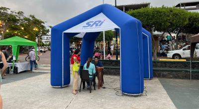 Un funcionario del SRI ofrece información a ciudadanos en un stand ubicado en una plaza, en el cantón Santa Cruz, en Galápagos, el 30 de julio de 2024. Imagen referencial.