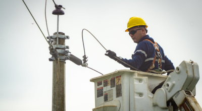 Técnico de CNEL realiza trabajos en un poste de luz.