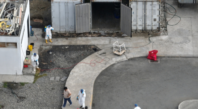 Personal desinfecta un contenedor con cadáveres sin identificar, luego de fallas en el sistema de refrigeración en el Laboratorio de Criminalística y Ciencias Forenses de Guayaquil, el 13 de junio del 2024.