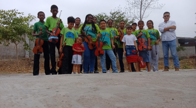 El profesor de música Henry Merchán, de 37 años, posa con uno de los grupos actuales de sus alumnos de violín en Socio Vivienda, al noroeste de Guayaquil.