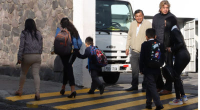 Personas caminan hacia una institución educativa de Quito el 2 de septiembre de 2024, en el día del inicio de clases del año lectivo en la Sierra.